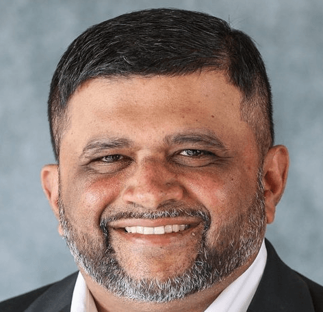 Portrait of Chetan Rao smiling in a suit.